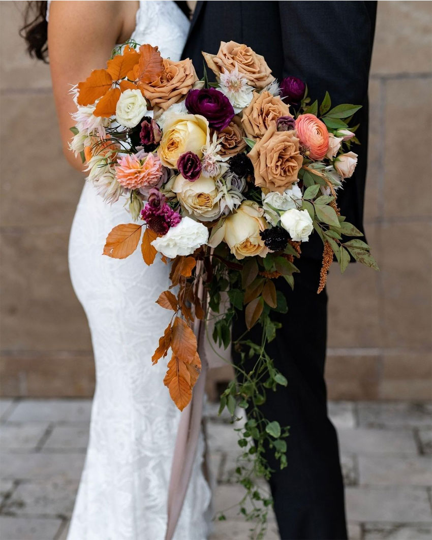 couples portrait with fall bridal bouquet full of roses