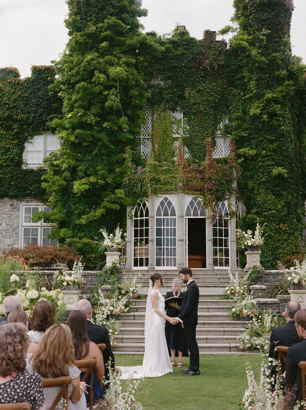 couple in front of wedding flowers at Luttrellstown Castle at Ireland wedding ceremony