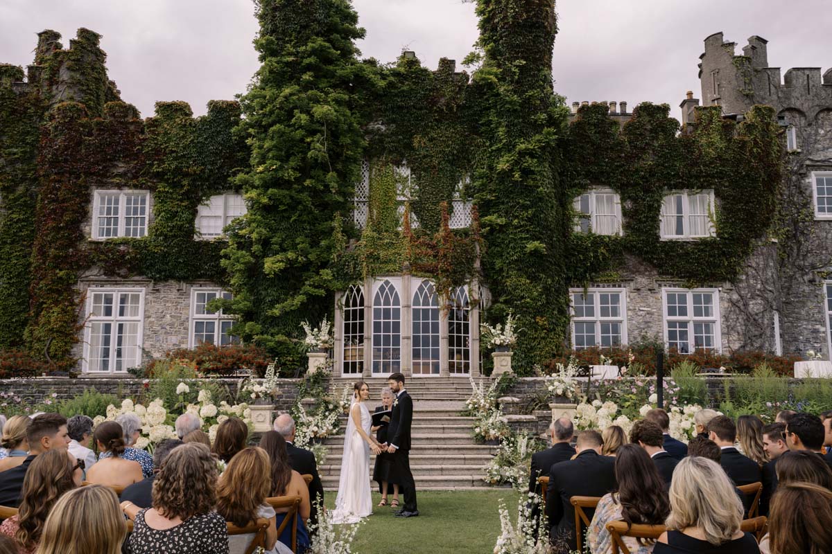 couple in front of wedding flowers at Luttrellstown Castle at Ireland wedding ceremony