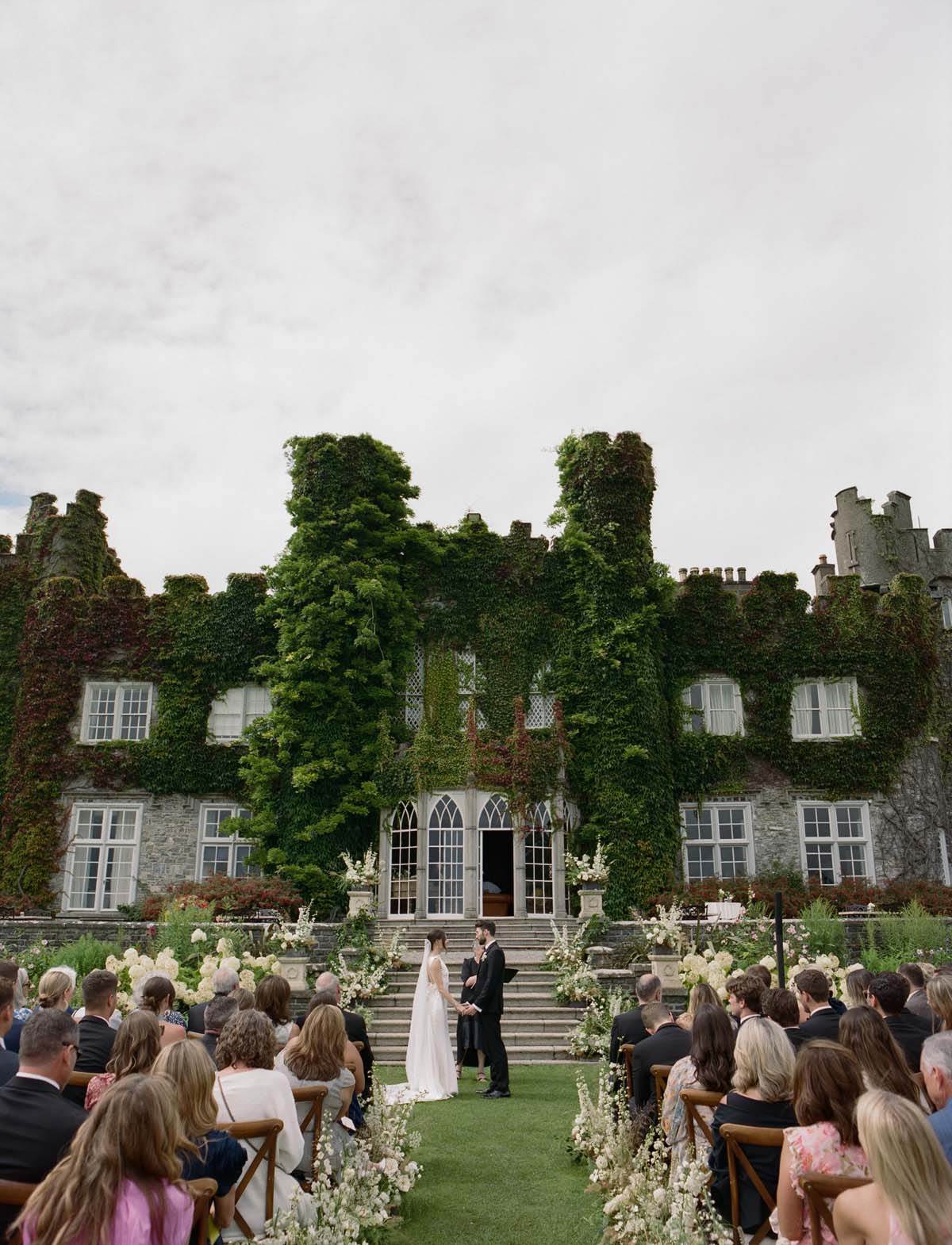 couple in front of wedding flowers at Luttrellstown Castle at Ireland wedding ceremony