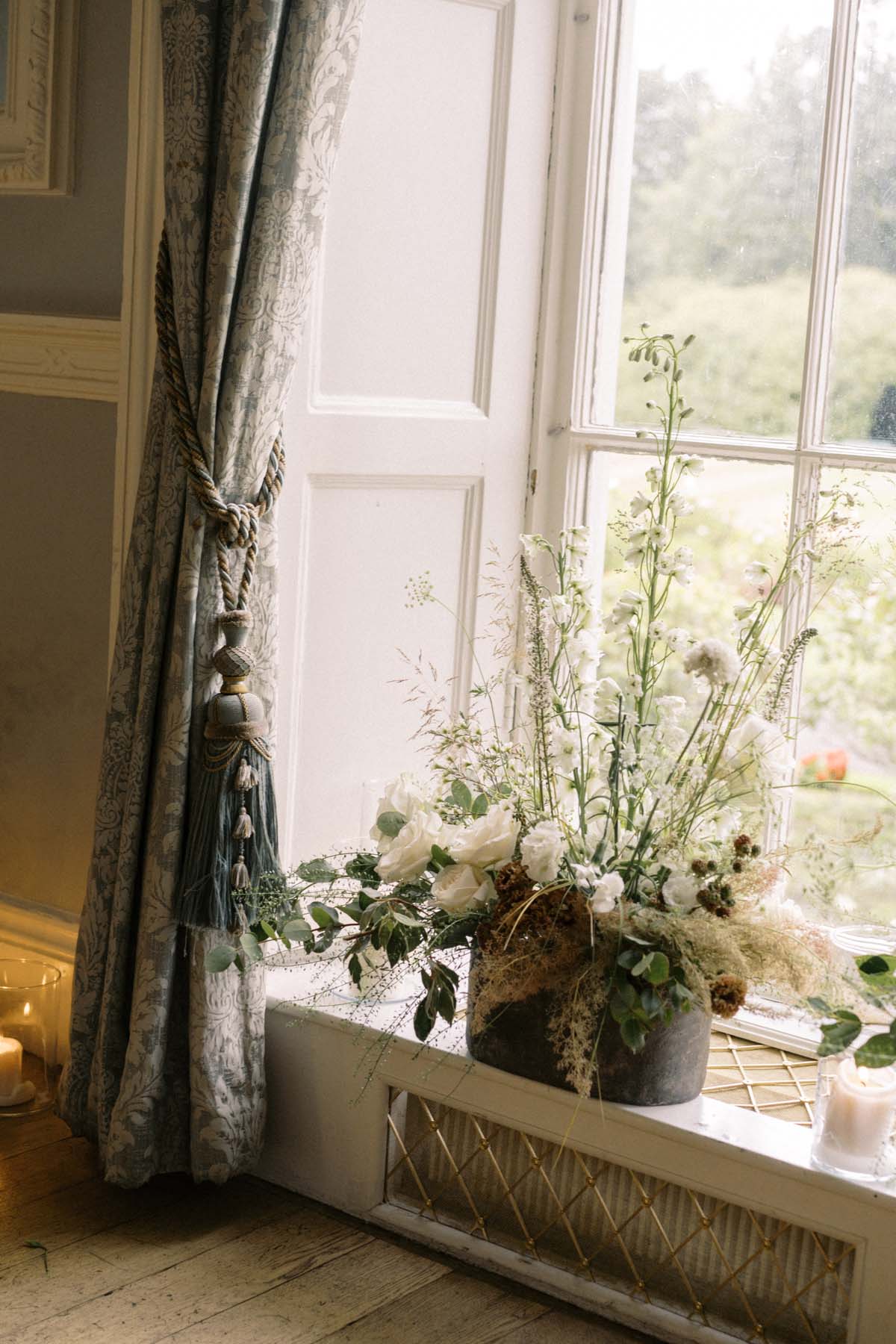 romantic white and green floral arrangements in window