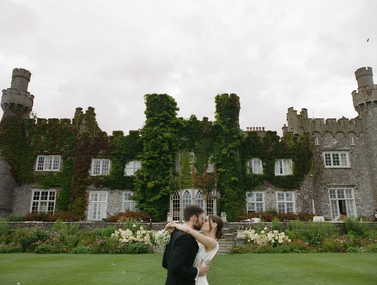 couple in front of wedding flowers at Luttrellstown Castle at Ireland wedding ceremony