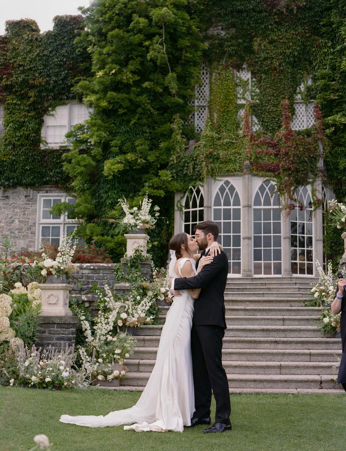 couple in front of wedding flowers at Luttrellstown Castle at Ireland wedding ceremony