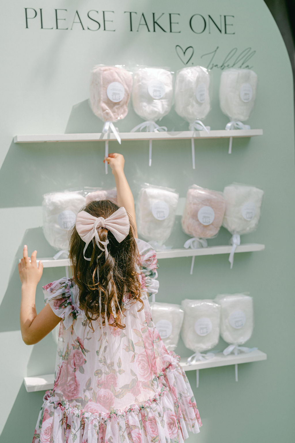 girl reaching for cotton candy wall at birthday party