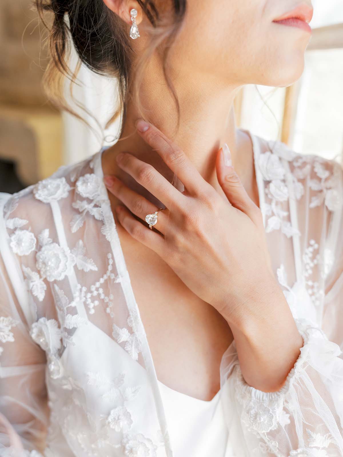 bride getting ready in lace robe with wedding ring