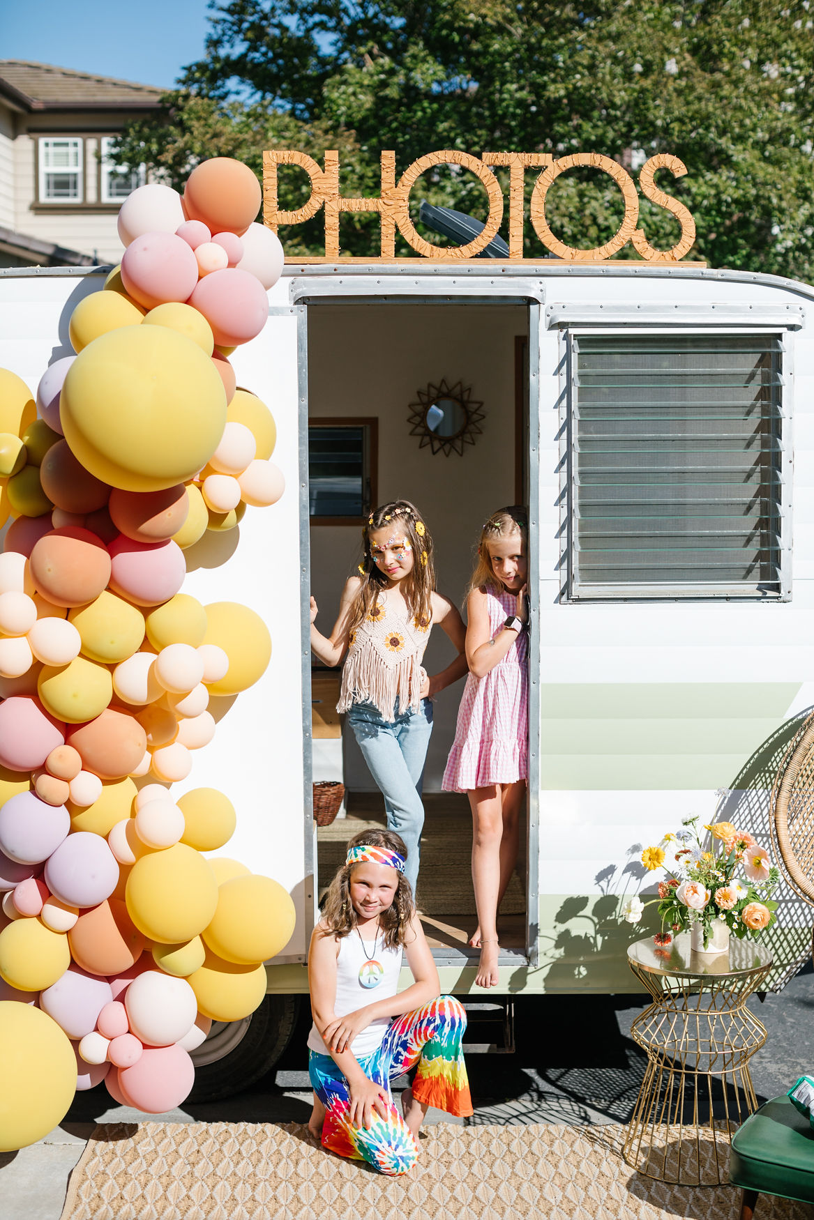 groovy hippie inspired photo booth for 60s 70s inspired birthday party with balloon decorations