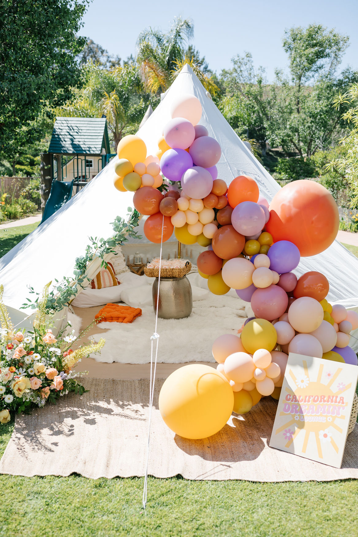 groovy colorful balloon decorations with boho tent for birthtday party