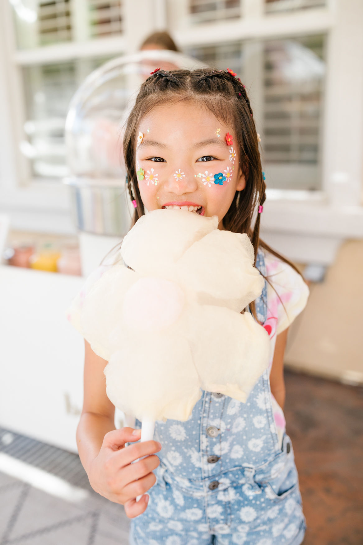 girl eating flower shaped cotton candy at groovy birthday