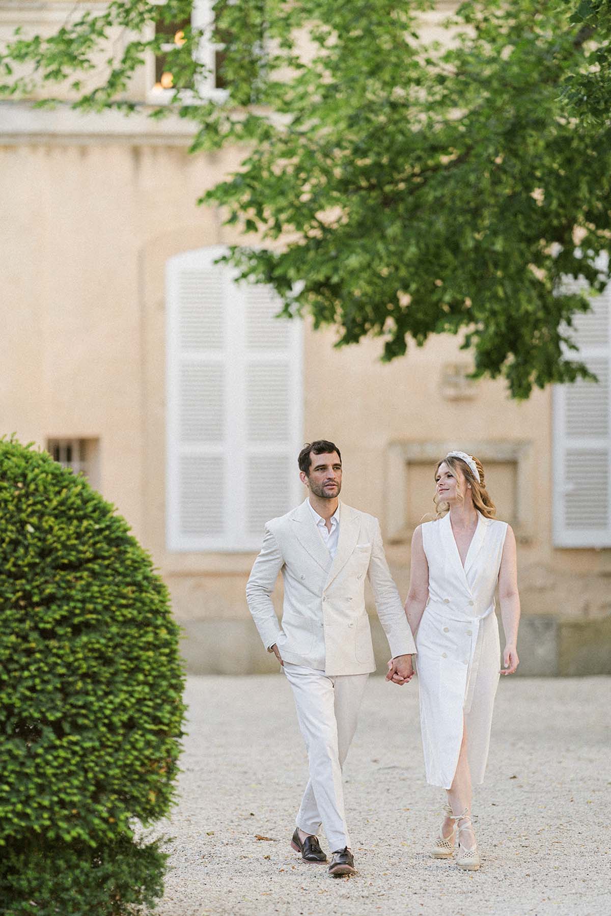 bride and groom wearing white at Chateau Martinay