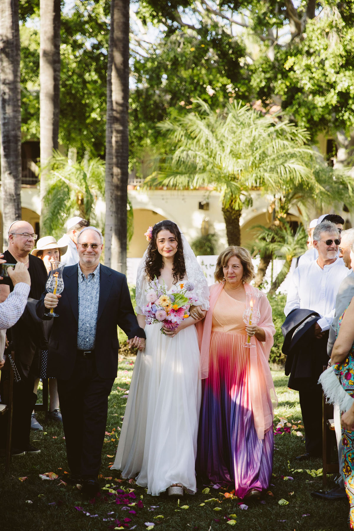 bride and parents walking down aisle at jewish wedding ceremony