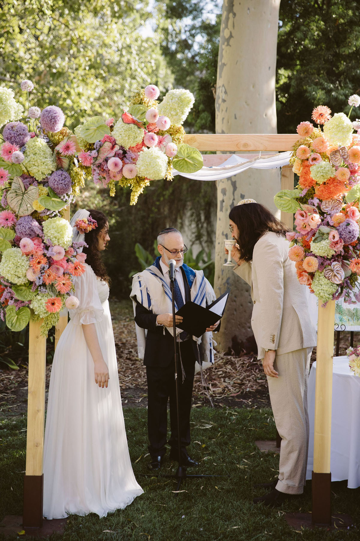 bride and groom in front of floral chuppah at LA River Center & Gardens wedding