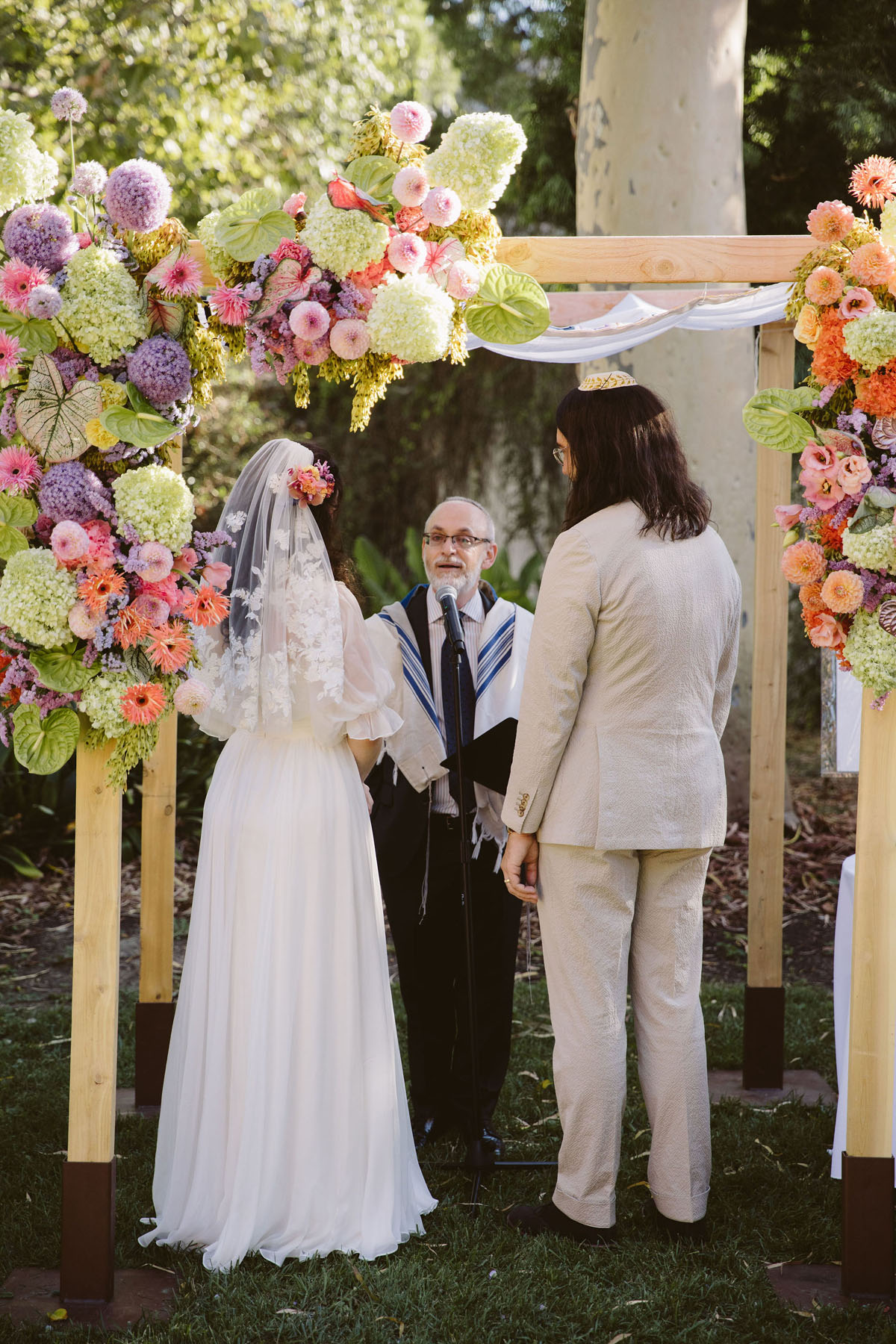 colorful chuppah with pink and green flowers