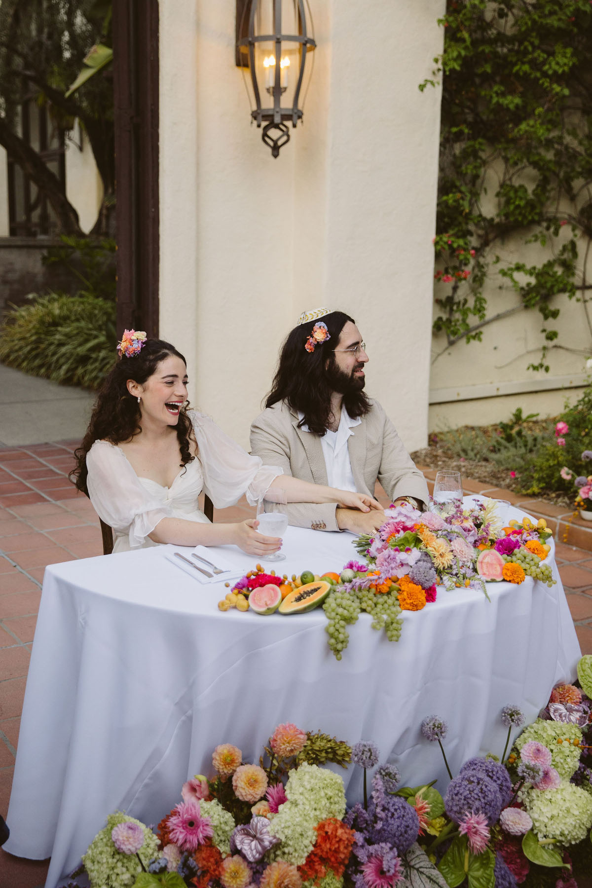 bride and groom at colorful sweetheart table