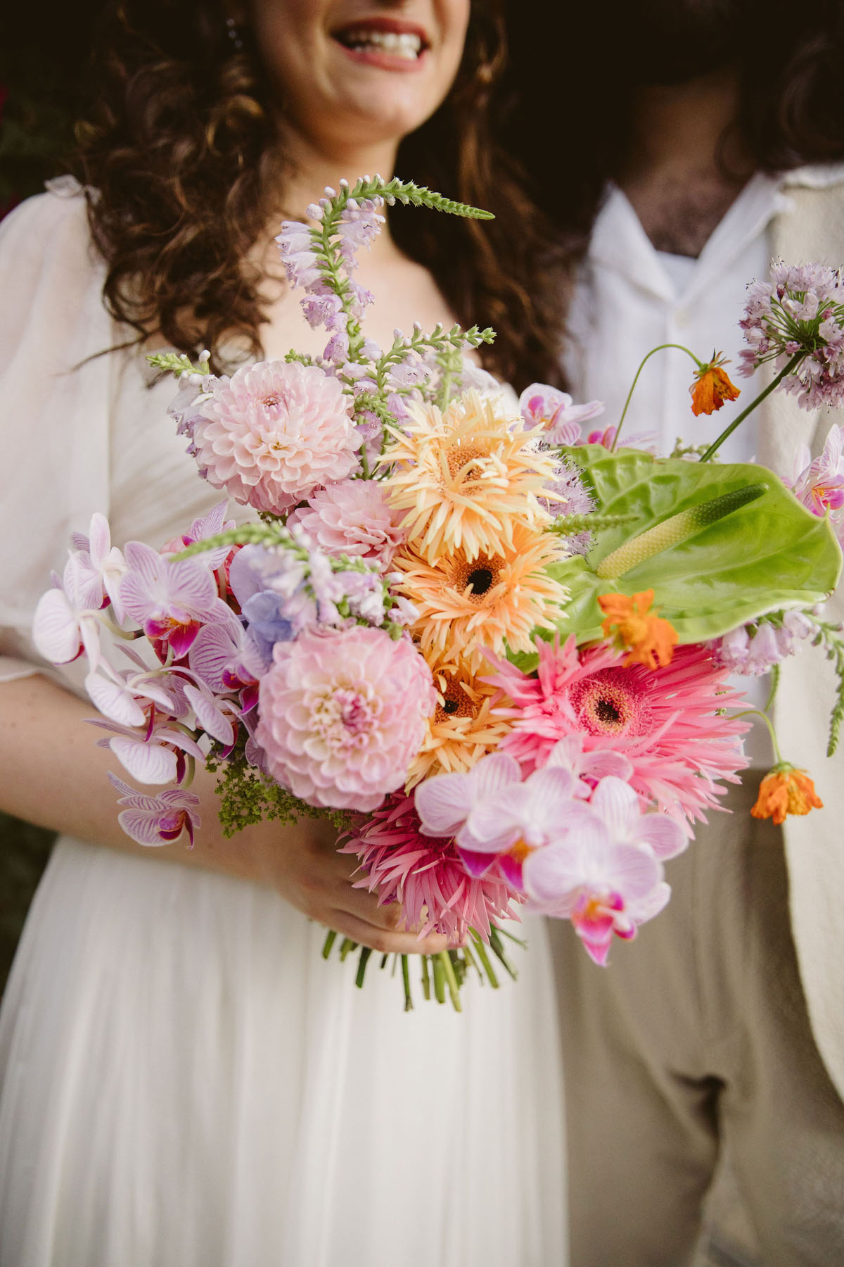 colorful bridal bouquet with pink, orange, green, and lilac