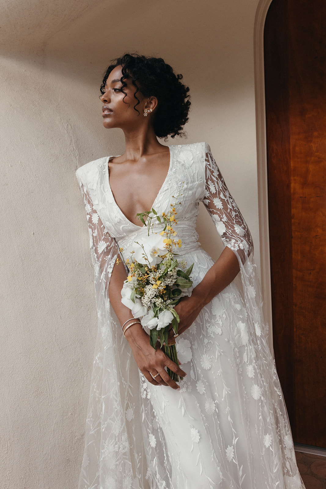 bride wearing lace cape dress