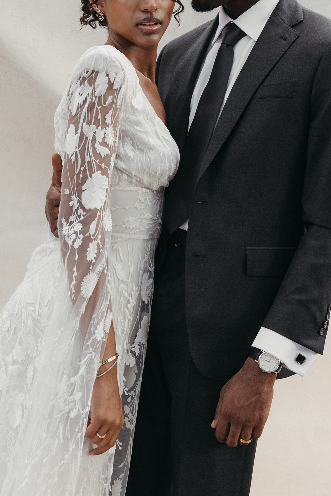  bride in lace wedding dress and groom in charcoal gray suit